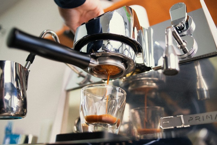 Espressor cu portafiltru care extrage un espresso